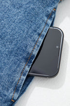 Smartphone in a pocket of blue vest on a white background