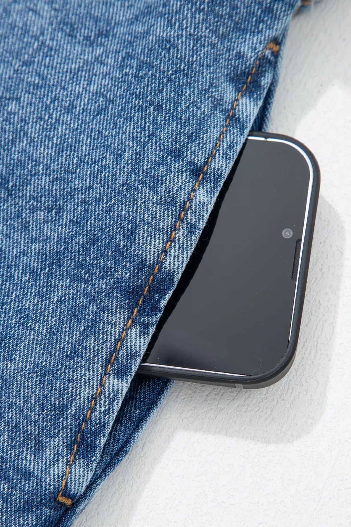 Smartphone in a pocket of blue vest on a white background