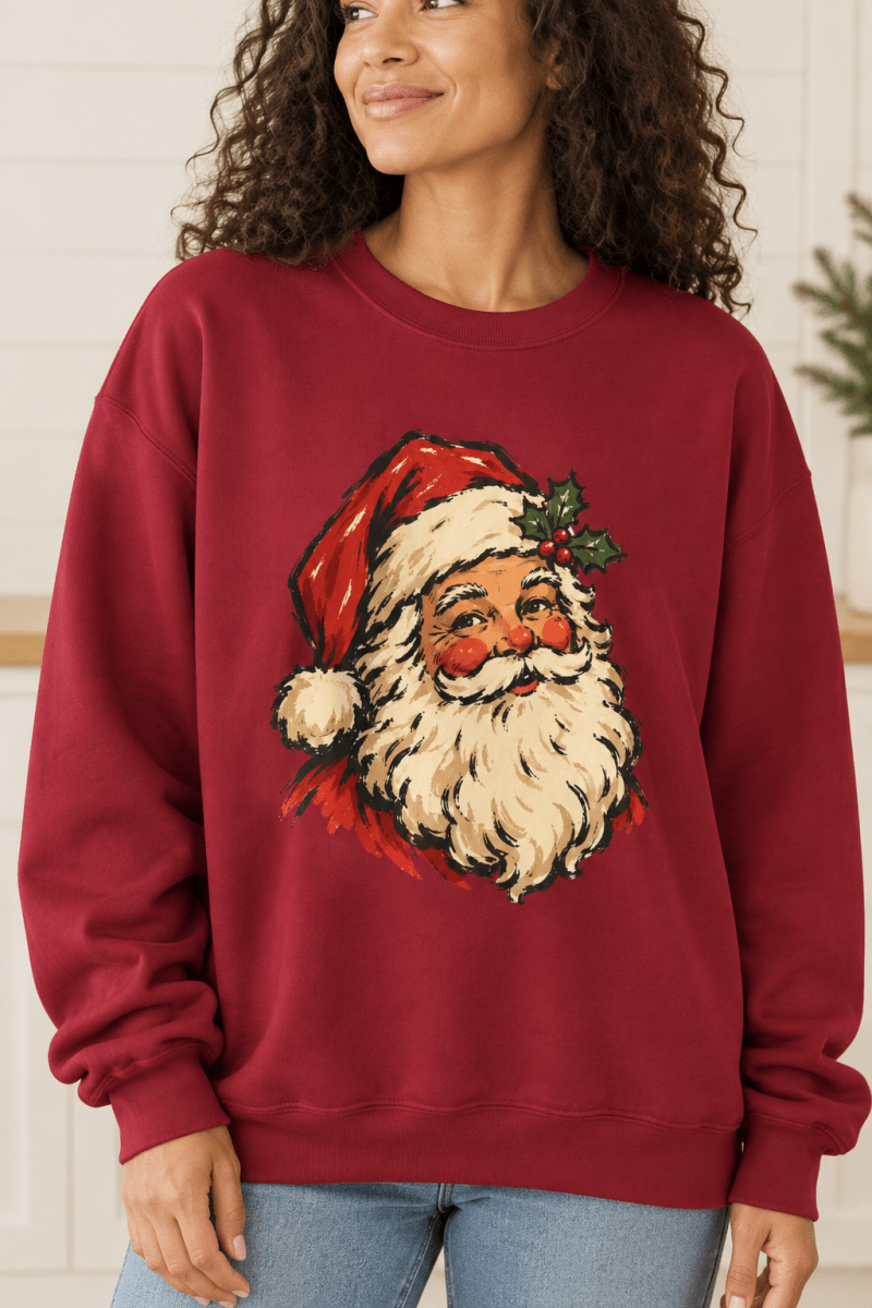 The Doodled Flower Boutique cardinal red crewneck sweatshirt featuring a vintage Santa portrait with a holly sprig graphic, close up.