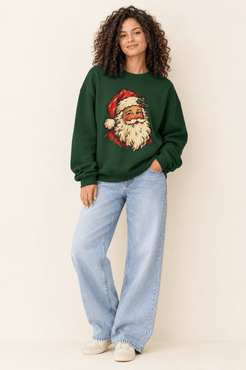 The Doodled Flower Boutique forest green crewneck sweatshirt featuring a vintage Santa portrait with a holly sprig graphic, worn by a model.