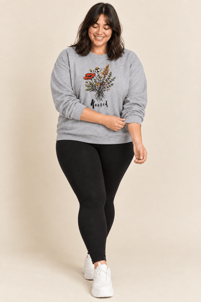 The Doodled Flower Boutique sport grey rooted floral crewneck sweatshirt styled with black leggings and chunky white sneakers.