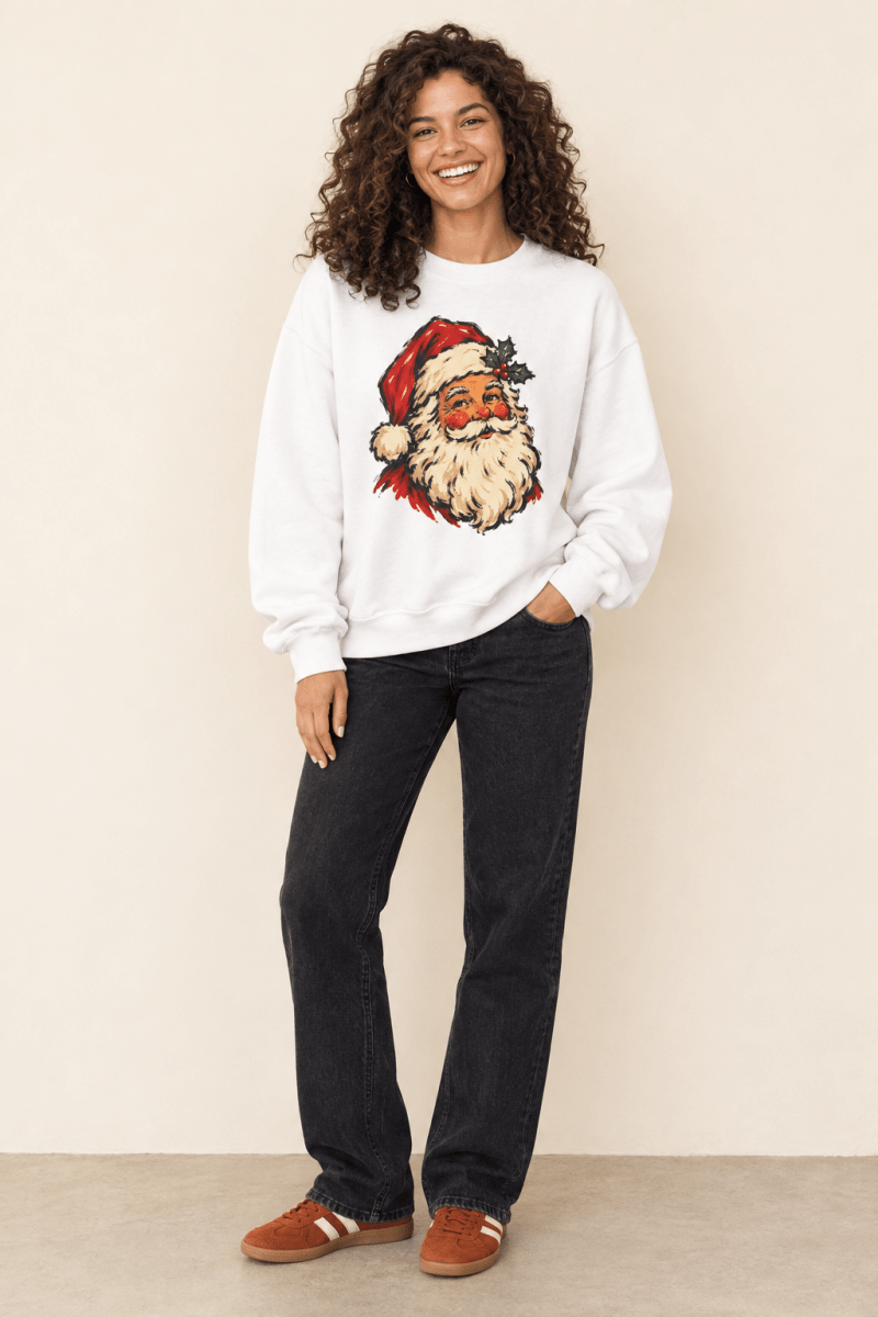 The Doodled Flower Boutique white crewneck sweatshirt featuring a vintage Santa portrait with a holly sprig graphic, worn by a model.