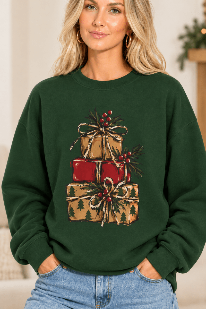 The Doodled Flower Boutique forest green crewneck sweatshirt featuring a stacked presents graphic with evergreen sprigs and red berries, close up.