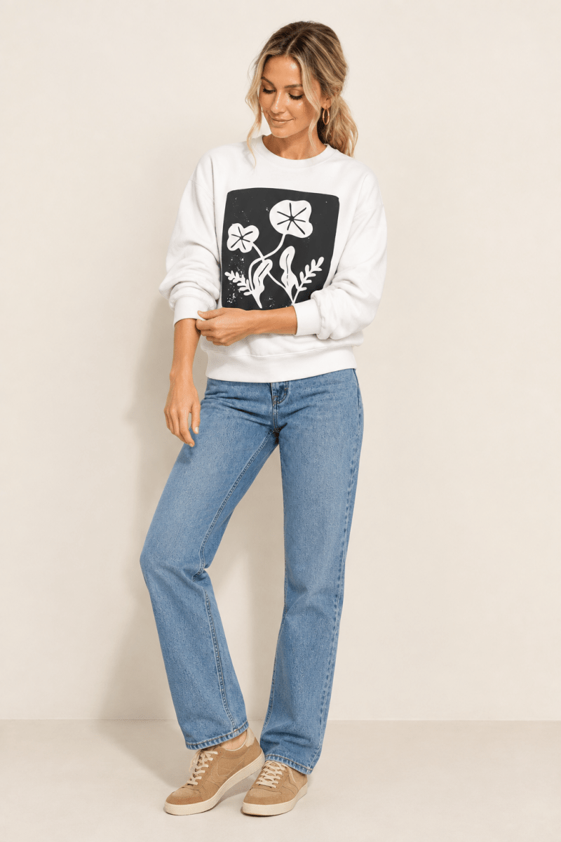 The Doodled Flower Boutique white floral block print crewneck sweatshirt styled with straight leg jeans and suede sneakers.