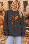 The Doodled Flower Boutique charcoal grey crewneck sweatshirt with autumn leaf and acorn print worn by a blonde model