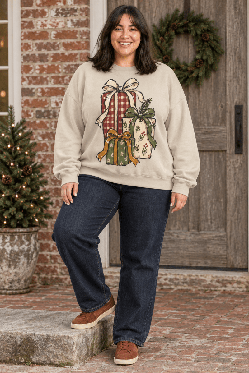 The Doodled Flower Boutique cream crewneck sweatshirt featuring hand-drawn Christmas gift stack illustration.