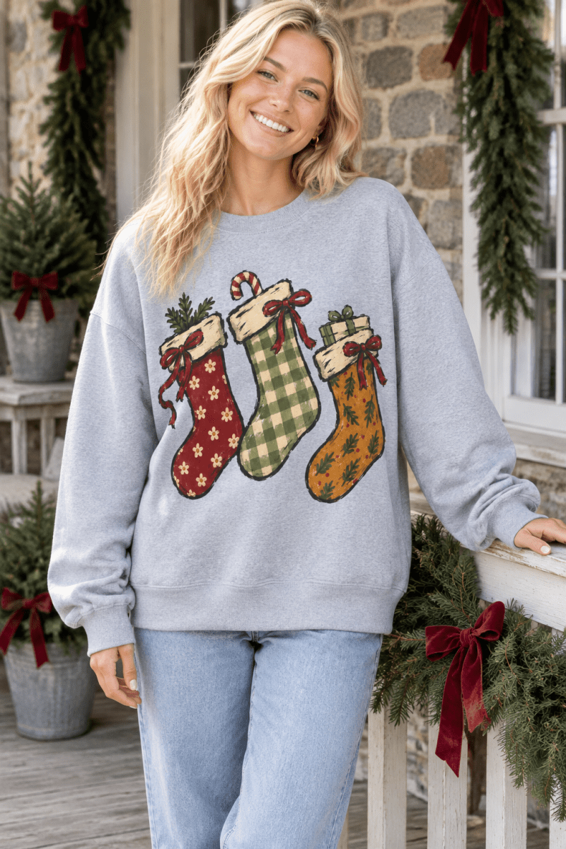 The Doodled Flower Boutique grey crewneck sweatshirt featuring hand-drawn Christmas stockings with festive patterns.