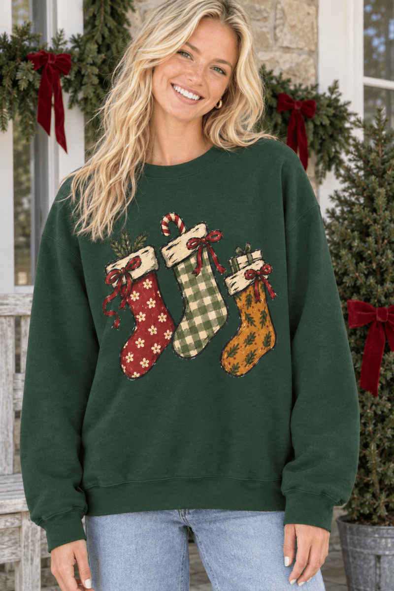 The Doodled Flower Boutique dark green crewneck sweatshirt featuring a hand-drawn print of three festive stockings.
