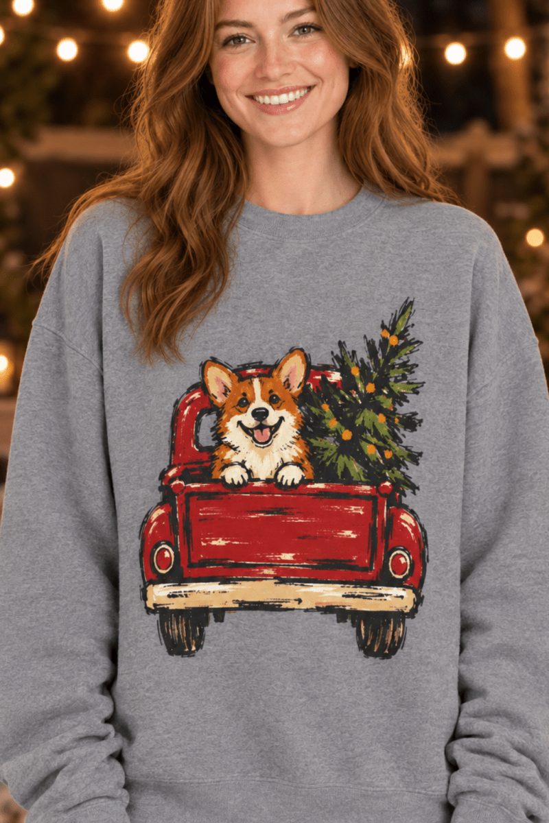 The Doodled Flower Boutique grey crewneck sweatshirt featuring a corgi in a red vintage truck with a Christmas tree.