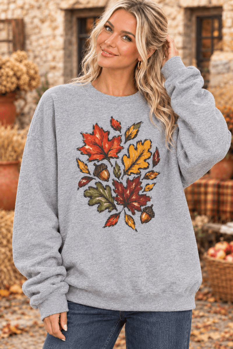 The Doodled Flower Boutique grey crewneck sweatshirt featuring a hand-painted autumn leaf and acorn design.
