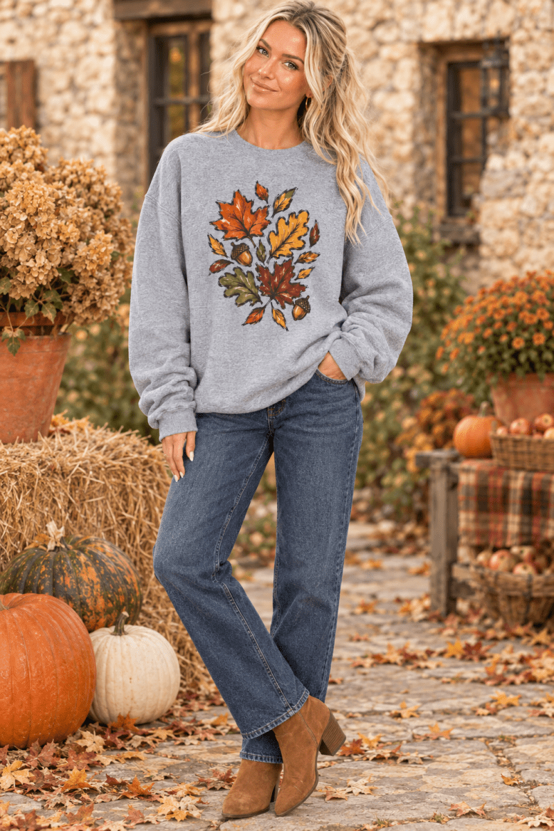 The Doodled Flower Boutique grey crewneck sweatshirt featuring a colorful autumn leaf and acorn graphic print.