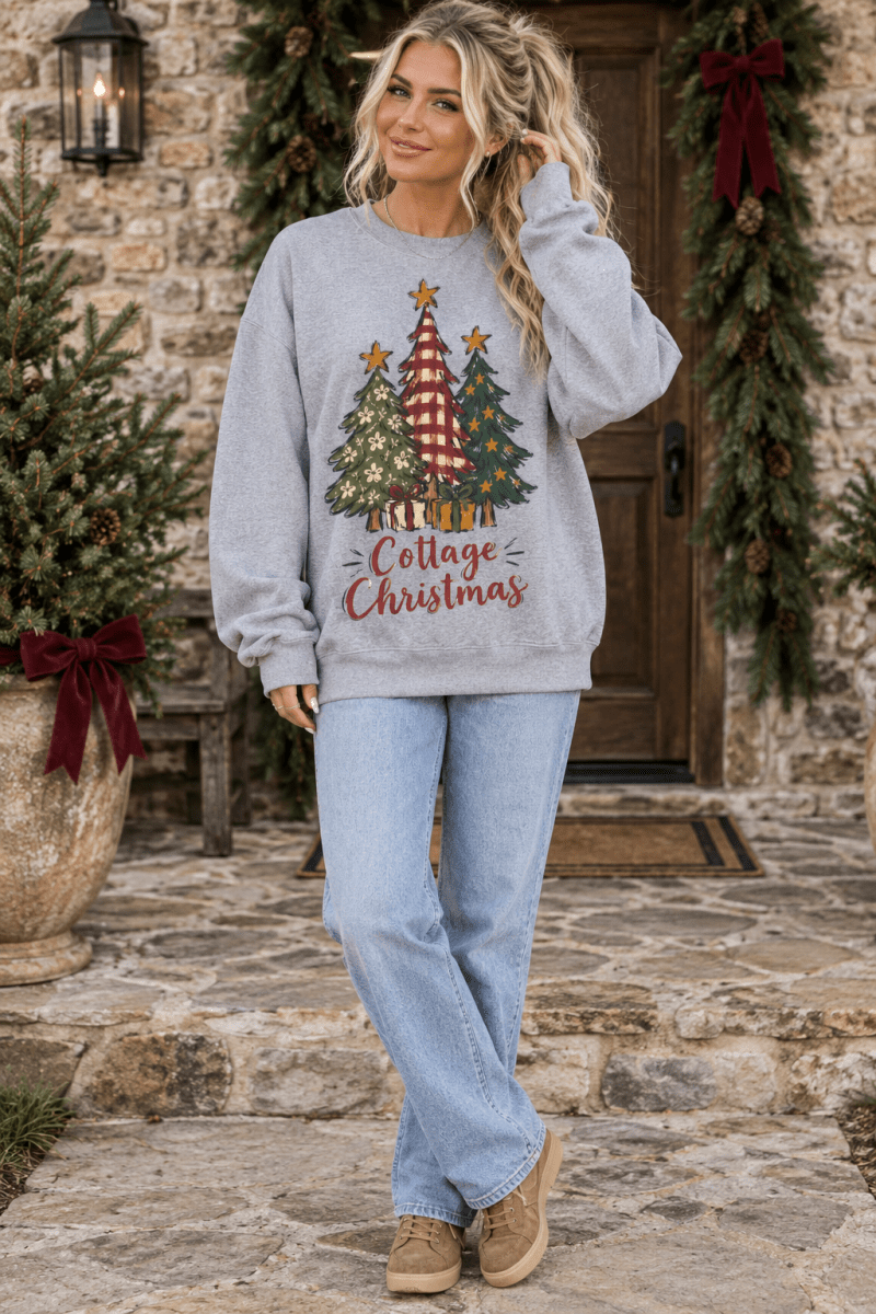 Woman wearing a grey The Doodled Flower Boutique sweatshirt with a festive Christmas tree graphic and cranberry text.