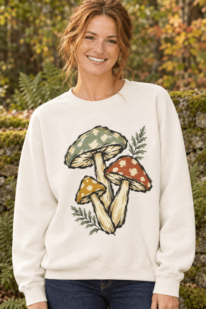 Woman wearing The Doodled Flower Boutique ivory crewneck sweatshirt with vintage botanical mushroom trio illustration