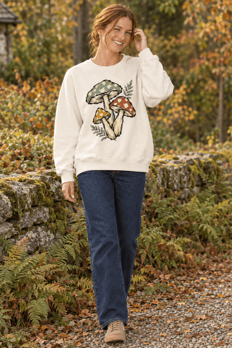 Woman wearing The Doodled Flower Boutique ivory crewneck sweatshirt with vintage botanical mushroom trio illustration