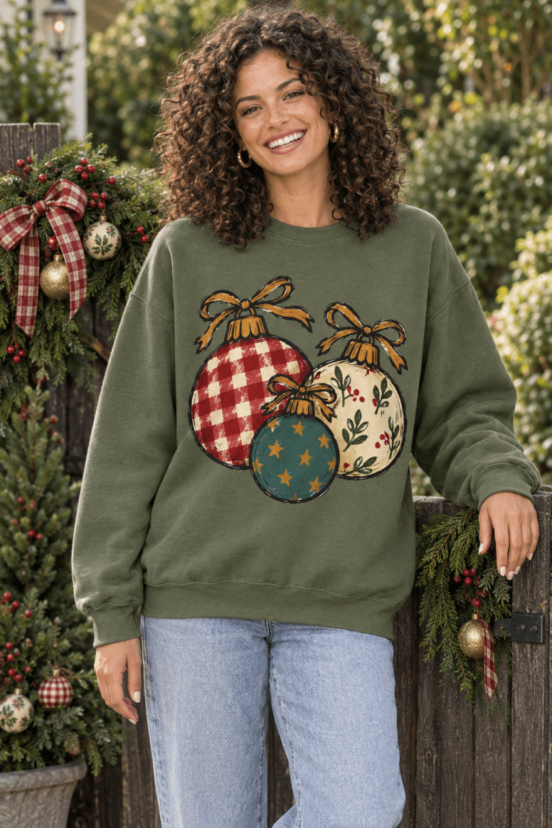 Woman wearing The Doodled Flower Boutique olive green crewneck sweatshirt with hand-drawn Christmas ornament print.