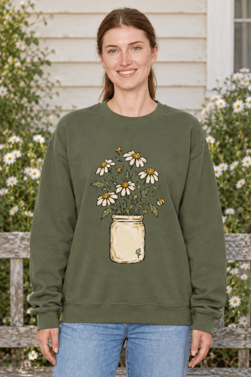 Woman wearing The Doodled Flower Boutique olive green fleece crewneck sweatshirt with a daisy bouquet jar graphic.