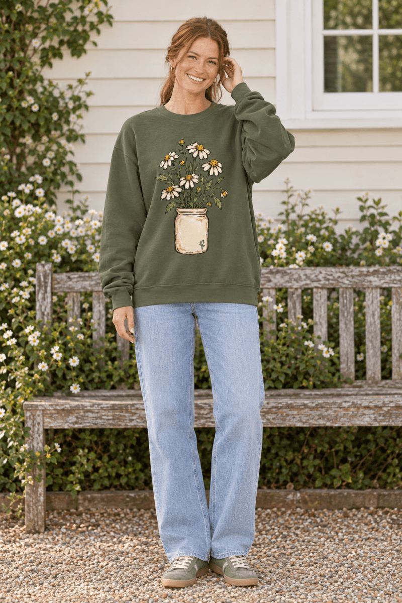 Woman wearing The Doodled Flower Boutique olive green crewneck sweatshirt with a daisy bouquet illustration.