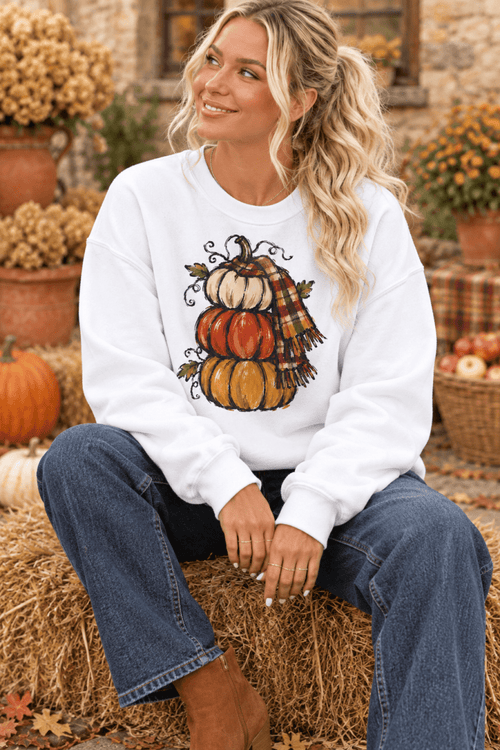 The Doodled Flower Boutique cream crewneck sweatshirt featuring a hand-drawn stacked pumpkin and plaid scarf design.