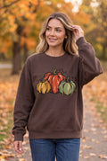 Woman wearing The Doodled Flower Boutique espresso brown cotton sweatshirt with watercolor pumpkin illustration