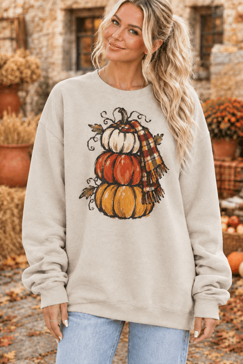 The Doodled Flower Boutique cream crewneck sweatshirt featuring a hand-drawn stacked pumpkin and plaid scarf design.