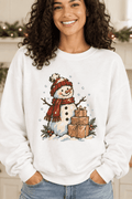 Woman wearing a The Doodled Flower Boutique white crewneck sweatshirt with a hand-drawn snowman and gift illustration.