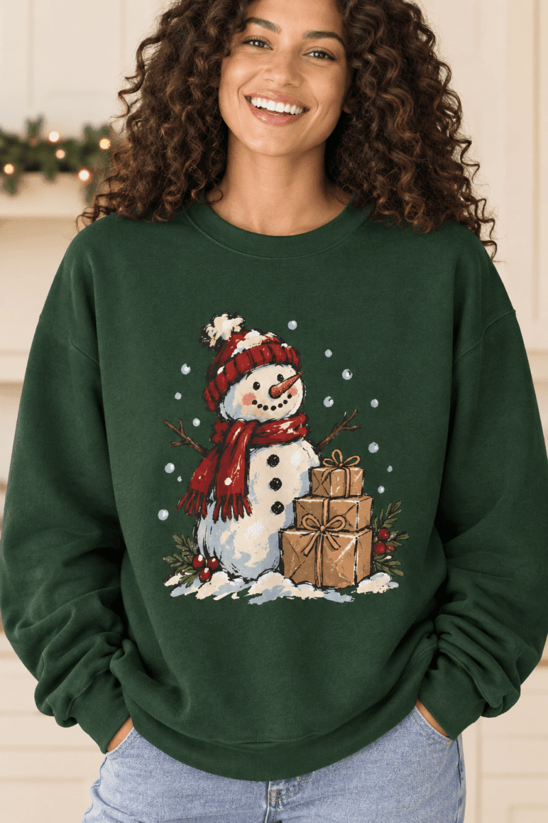 The Doodled Flower Boutique dark green crewneck sweatshirt featuring a hand-drawn snowman with gifts and snow
