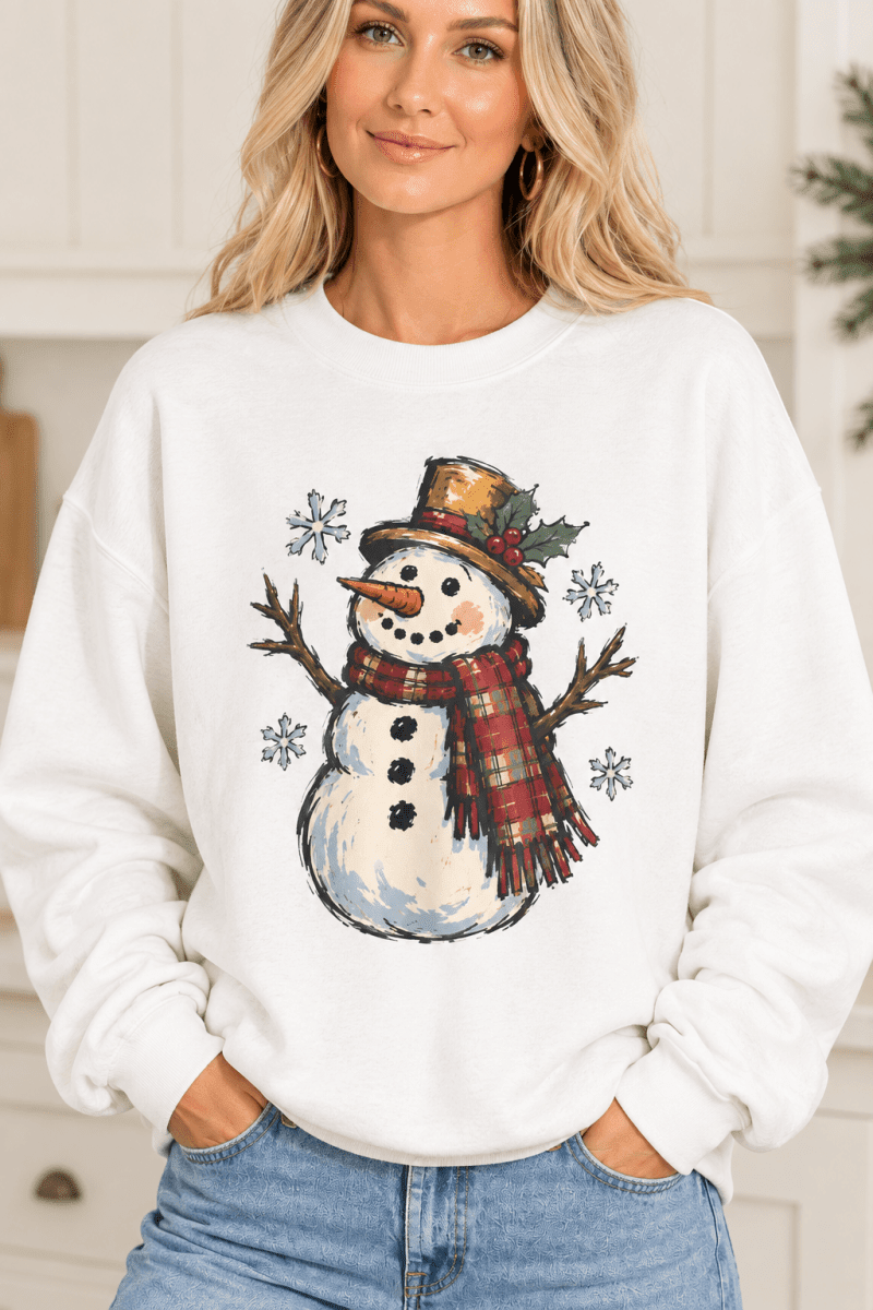 The Doodled Flower Boutique white crewneck sweatshirt featuring a vintage snowman illustration with a plaid scarf.