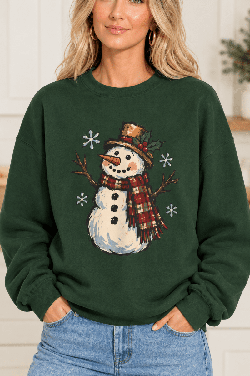 The Doodled Flower Boutique dark green crewneck sweatshirt featuring a vintage snowman illustration with a plaid scarf.