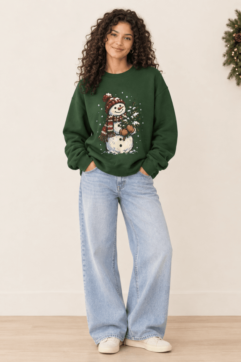 The Doodled Flower Boutique dark green crewneck sweatshirt featuring a hand-drawn snowman graphic with a Christmas tree