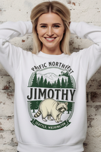 A woman wearing a white crewneck sweatshirt with a green and beige graphic of a raccoon, mountains, and trees, with the text 'PACIFIC NORTHWEST JIMOTHY SEATTLE, WASHINGTON'.